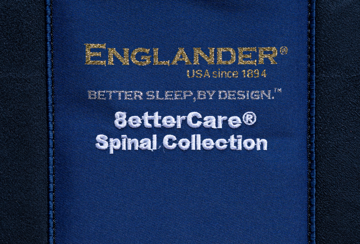 Close-up of a blue strap with 'Englander' branding on a product, featuring 'Better Care Spinal Collection'.