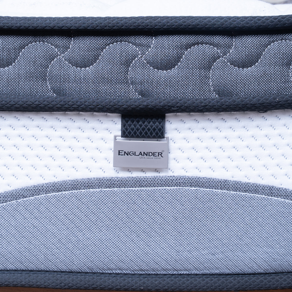 Close-up of a mattress with 'Englander' branding on a white background