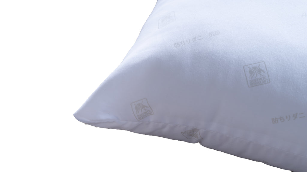 A close-up of a white pillow with a subtle repeating logo pattern, shown against a plain white background.