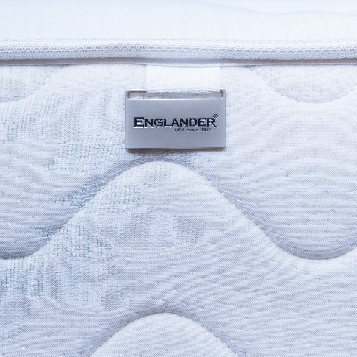 Close-up of a Spinal Shield mattress with 'Englander' branding.