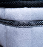 Close-up of a textured fabric with braided trim on a white background